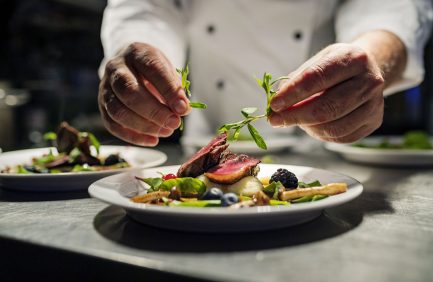 chef prepares dish at farm to table restaurant in New York City