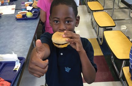 CHILD EATING CHEESEBURGER