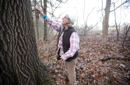 Evelyn Franklin uses spray paint to mark trees “DNC” (Do Not Cut) for the ones she wants to keep on her farm.