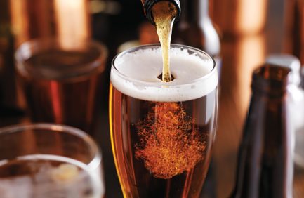 Pourng a stout dark beer from bottle into glass