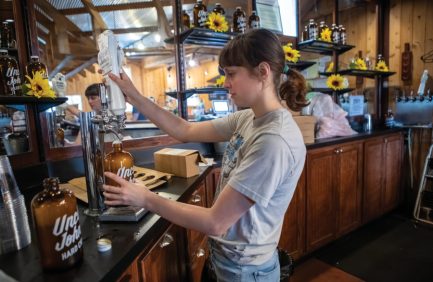 An Uncle John's Cider Mill employee pours hard cider for visitors