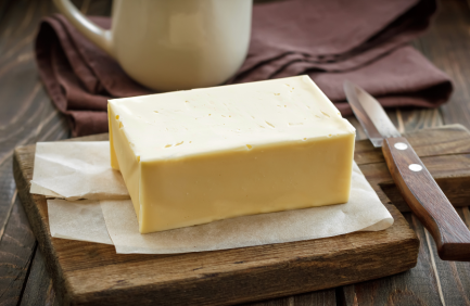 A block of butter on a wood cutting board