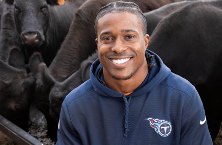 Former NFL linebacker Avery Williamsons surrounded by his cows on the family farm in Milan, Tennessee.