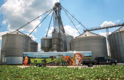 Mobile Science Activity Center parked beside grain bins and silos